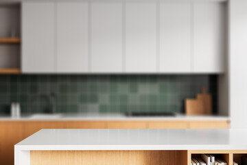 Modern kitchen interior with white countertop table for product mockup display and blurred green tile background in warm contemporary style. 3D Rendering