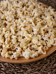 Butter salted popcorn on wooden table.