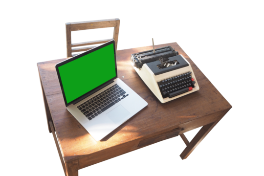 A laptop and vintage typewriter on a wooden desk, showcasing the blend of technology and nostalgia.