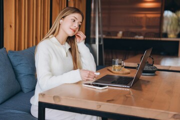 Freelancer enjoying working remotely from cafe, listening music and drinking tea