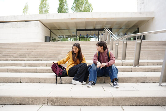 Two teenagers sitting on steps at school