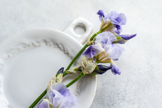 From above purple Iris flowers on a vintage white plate