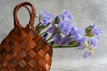 Woven basket with Iris flowers against a rustic background