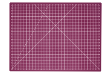 Large pink cutting mat with white grid and measurement marks is isolated. Top-down view.