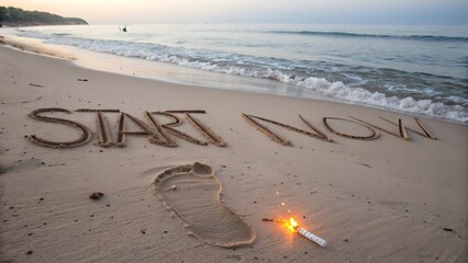 Message start now written in sand with sparkler and footprint on beach