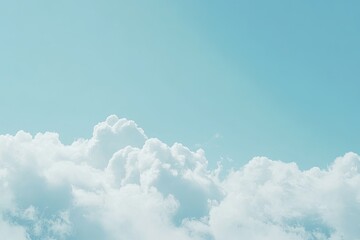 A serene blue sky with fluffy white clouds filling the bottom half of the frame
