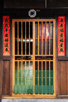 Ornamental yellow door with Chinese couplets, Chew Jetty, Malaysia