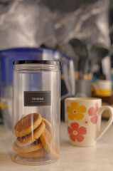 Cookies in a jar on the kitchen table. 1
