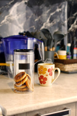 Cookies in a jar on the kitchen table.