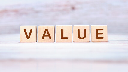Business concept. VALUE written on wooden cubes on a delicate pastel background