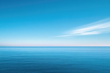 A vast expanse of calm blue ocean meets a clear, bright sky with a single wisp of white cloud