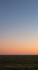 Fototapeta premium Serene Sunset over Vast Grassland Plains Breathtaking Twilight Landscape