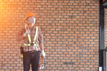 Smiling technician installing air conditioner indoors