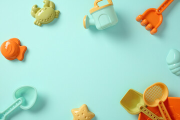 Kid's summer beach toys collection forming a frame on blue background