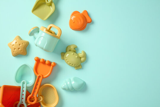 Pastel colored beach toys for kids on turquoise background. Flat lay, top view