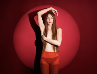 Young woman posing against a red circular background in studio