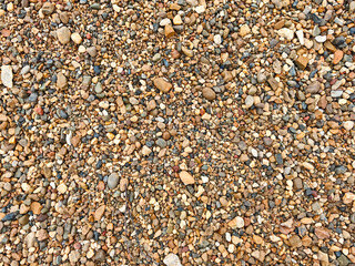 Natural gravel and pebbles create a textured landscape on a sunny day in a remote location