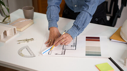 Asian adult architect hands drawing blueprint on desk with tools Home design and Asian adult architect hands working for construction planning ideas