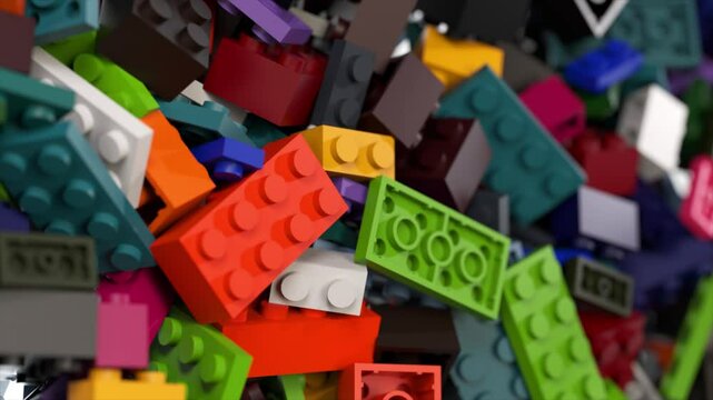 Colorful plastic construction bricks are falling, bouncing, and accumulating on a clean white background, creating a vibrant and playful scene
