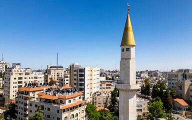 Golden minaret in downtown Ramallah, Palestine, framed against a deep blue sky