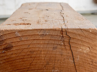 Close-up view of weathered wooden beam with cracks and natural grain