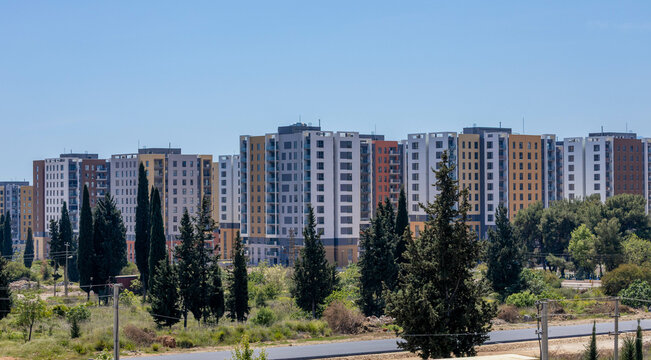 Modern residential area with multi-story apartment buildings surrounded by greenery under blue sky. Kepez, Antalya, Turkey, Mediterranean.