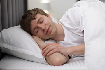 Young man sleeping in bed at home
