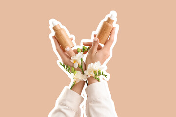 Female hands with bottles of cosmetic products and flowers on beige background