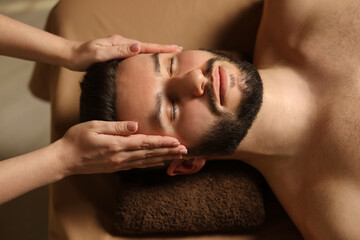 Man receiving relaxing massage in spa salon, above view