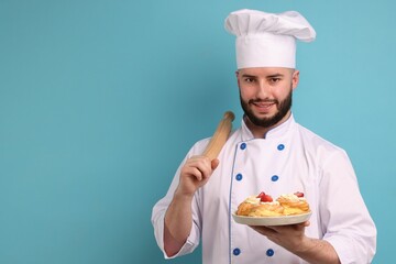 Happy confectioner in uniform holding delicious profiteroles with strawberries and rolling pin on...