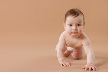 Cute little baby crawling on beige background. Space for text