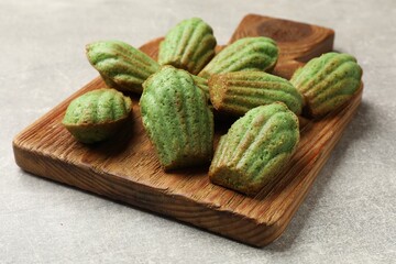 Tasty matcha madeleine cakes on light grey table, closeup