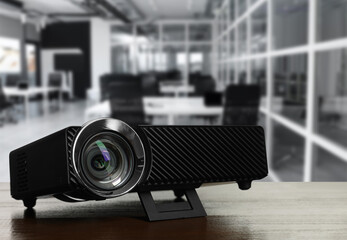 Modern video projector on wooden table in office