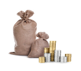 Wealth. Stacked coins and burlap bags isolated on white