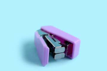 Lilac stapler on blue background