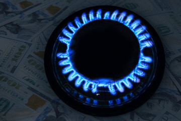 Gas burner with blue flame and dollar bills, double exposure. Gas tariff