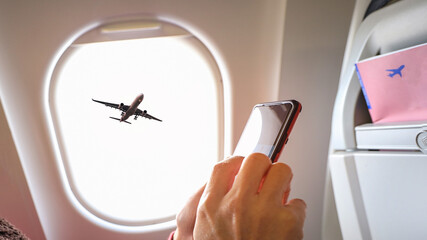 Sunset sky view from the airplane window  with man hand with smart phone