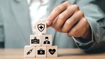 Essential Medical Care: Healthcare Symbols on Wooden Cubes in Hand