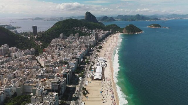 Aerial ascend over Copacabana Beach with ocean, Sugar-loaf mountain, and city skyline in Rio de Janeiro