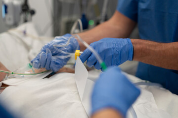 Medical team placing iv catheter into patient's arm in hospital operating room