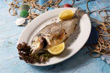 grilled fish, whole fish, seafood, lemon, sea bream, dorado, food photography, rustic, gourmet, plate, lettuce, Mediterranean, fish dish, ocean theme, cooked fish, fresh, herbs, roasted, main course, 
