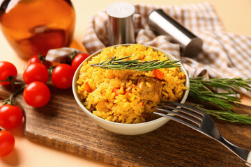 Bowl of tasty pilaf with rosemary and cherry tomatoes on orange background, closeup