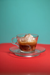 Affogato served in glass cup with whipped cream and espresso.
