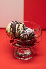 Two scoops of ice cream topped with chocolate and coconut.