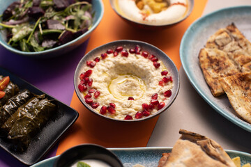 Colorful Lebanese mezze spread with moutabal, vine leaves, and bread.