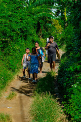 Obraz premium A warm moment as parents engage in conversation while walking home with their children along a country path.