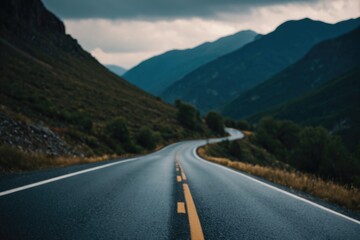 Fototapeta premium A long stretch of empty road winding through mountains