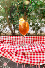 Aperol spritz served chilled with orange slice, outdoor setting.