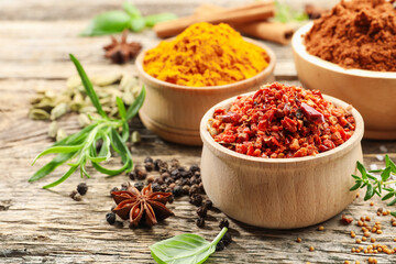 Different aromatic spices on wooden table, closeup