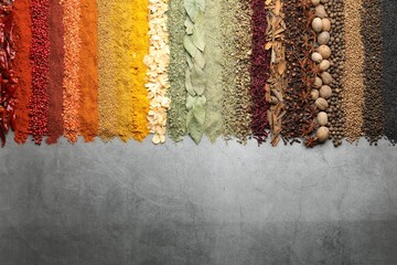 Many different spices on grey table, flat lay. Space for text